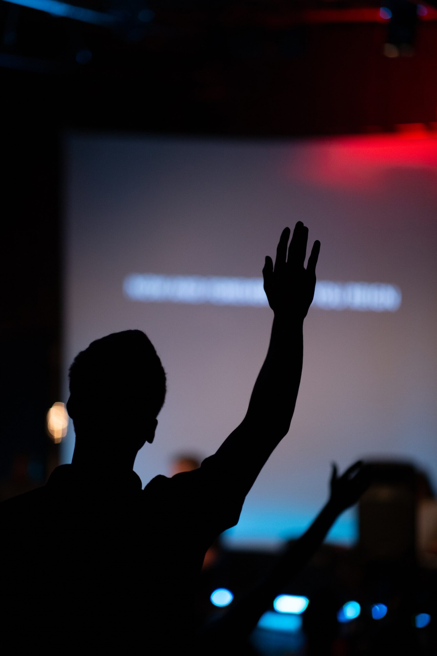 Person with a hand raised to ask a question